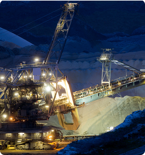 A large crane operates in a mine, used by electrical maintenance mining contractors for heavy lifting tasks