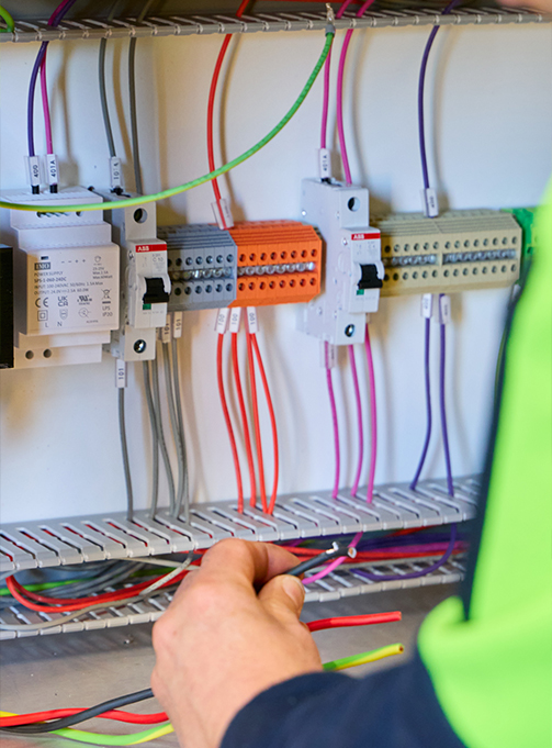 A technician performing electrical repairs and maintenance in a bright room, providing reliable electrical services near me