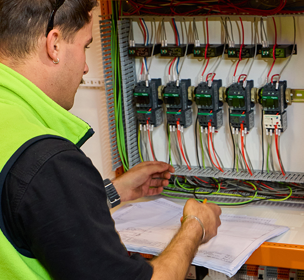 A technician in a safety vest installs electrical panels with precision, delivering trusted electrical services near me